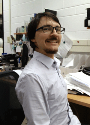 Jamie Ahloy Dallaire smiles while seated in lab