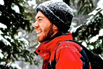 Kevin standing in snowy evergreen forest wearing jacket and toque.