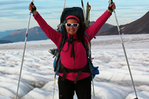 Laurissa Christie holds up poles while hiking across glacier.