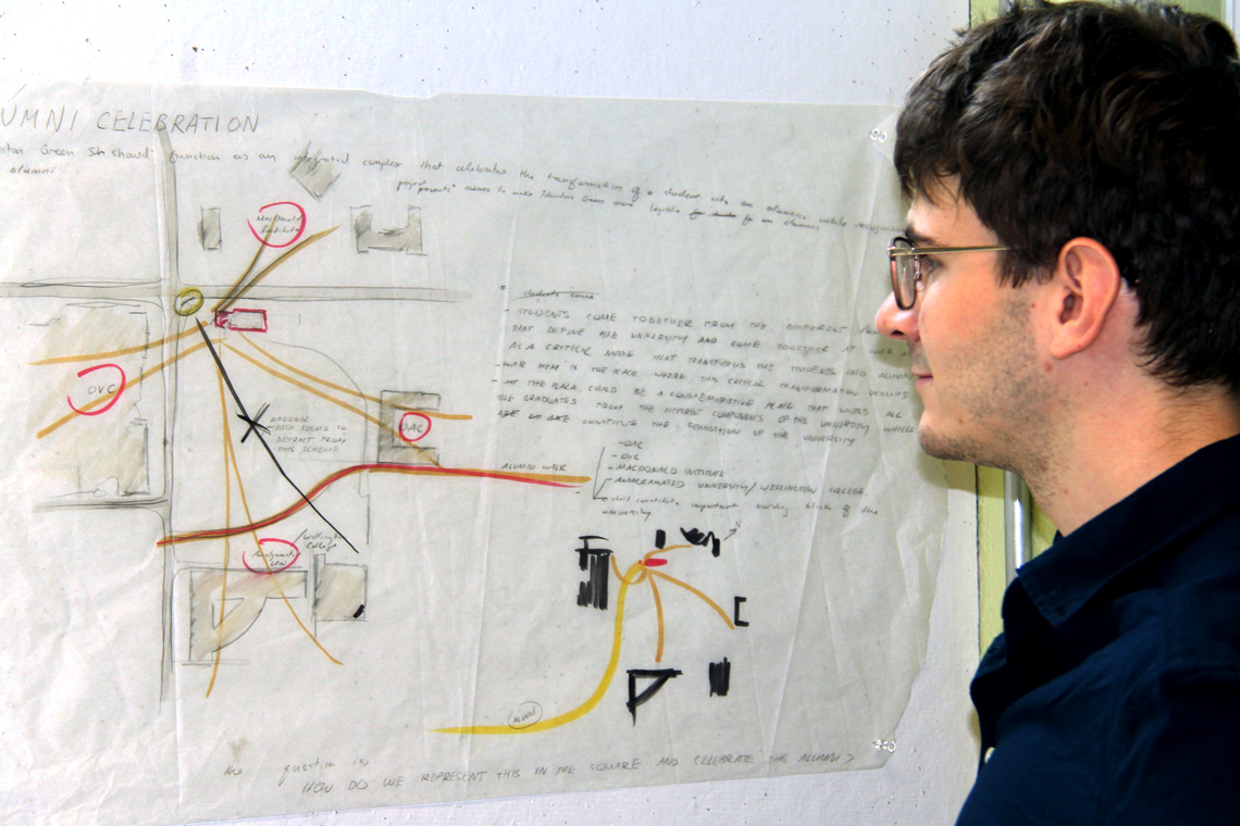 Michal looks at a coloured pencil sketch pinned on the wall.