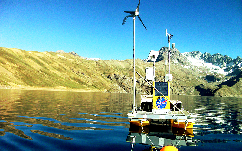 NASA equipment floating on lake with mountains behind