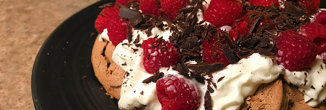 Close up of a raspberry pavlova on a plate.