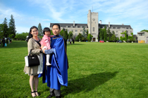 Qin stands with daughter and husband on Johnston Green on husband's graduation day.