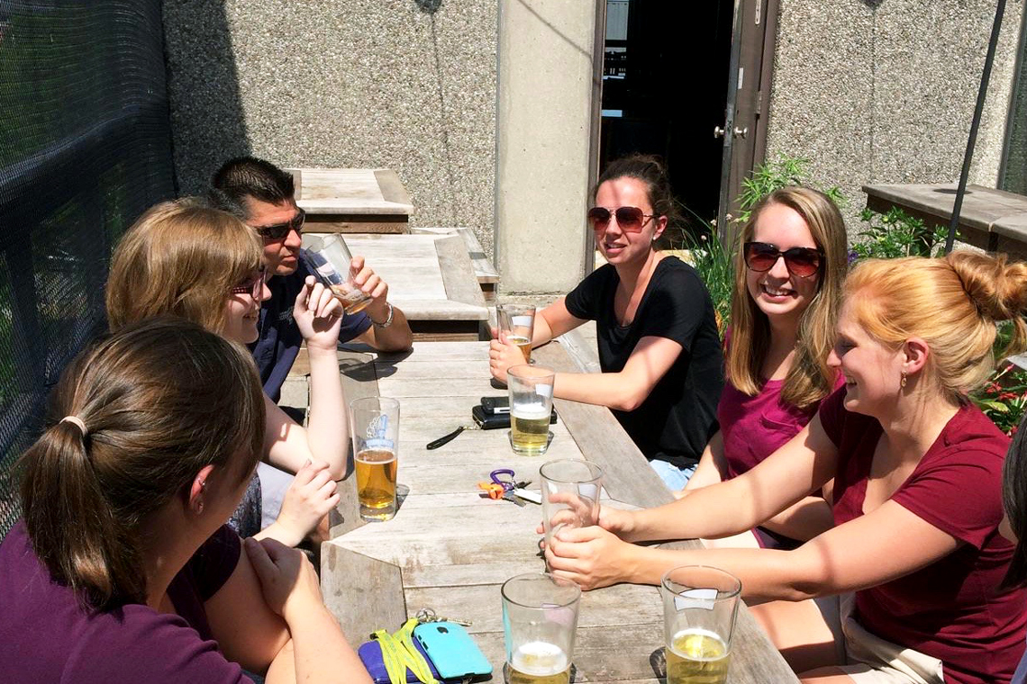 Rachael sits out on the Grad Lounge patio with a group of coworkers.