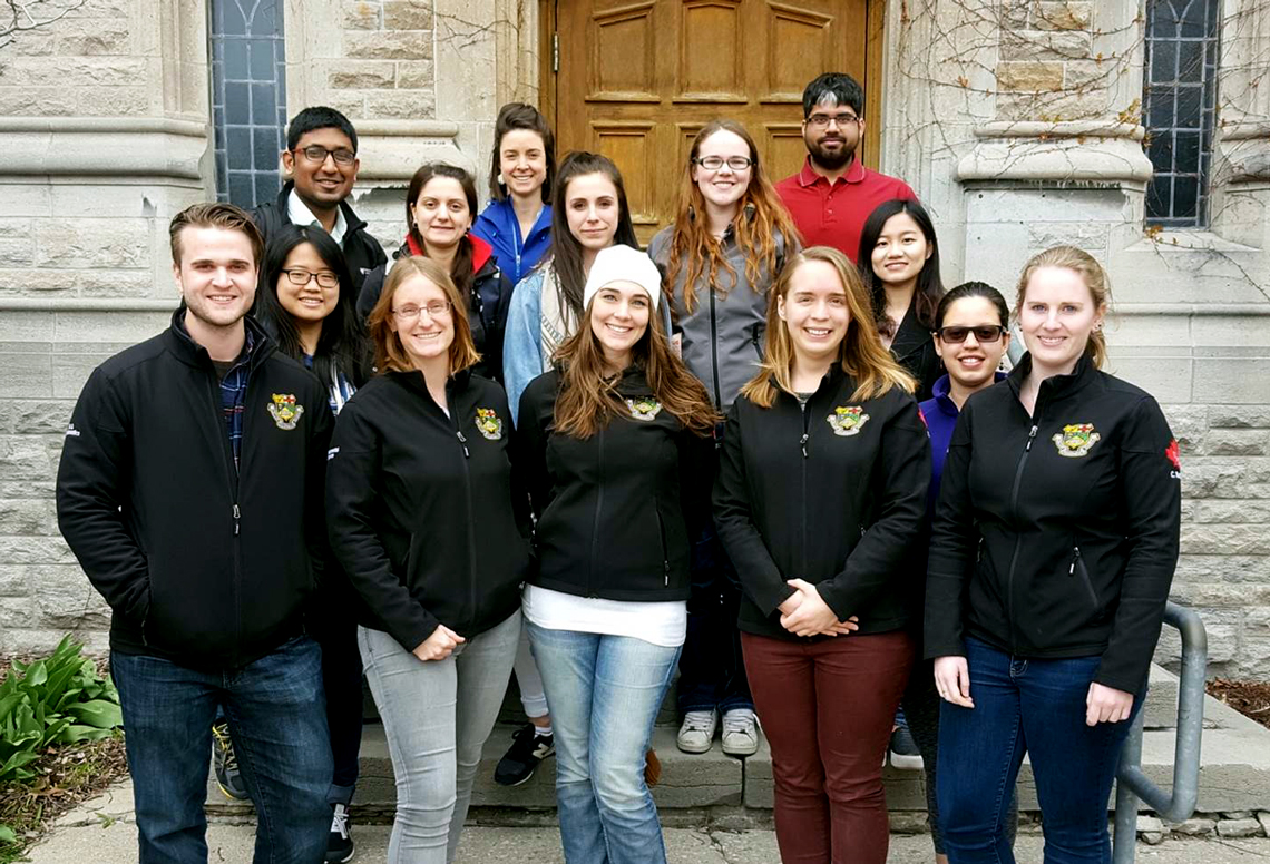 The OAC Graduate Student Council stands on the steps of Johnston Hall.