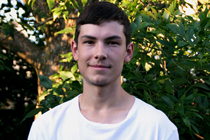 Simon Bissonnette stands outside under a tree.