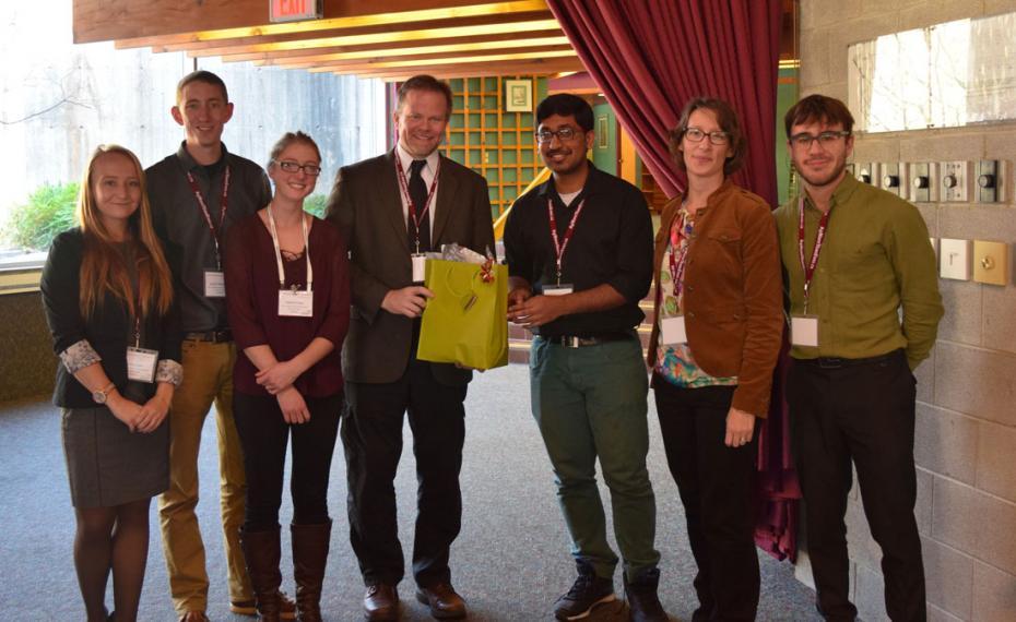 Student organizers stand with Kevin Folta and present him with a gift