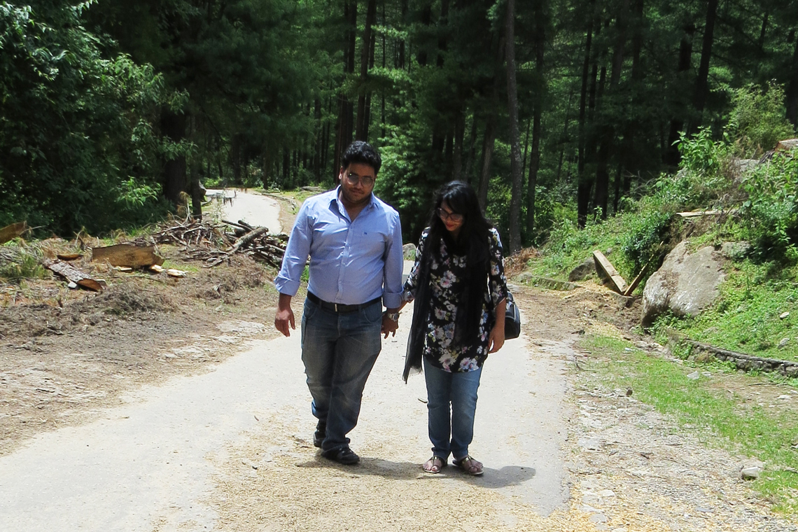 Syer walks with wife on a pathway through the forest.