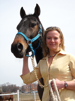 Wendy Pearson standing with brown horse wearing blue halter