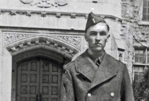 Man in uniform in front of Johnston Hall. 