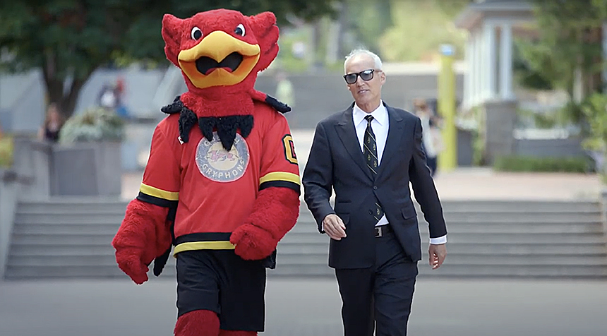 President Dr. Franco J. Vaccarino and University of Guelph mascot Gryph walking