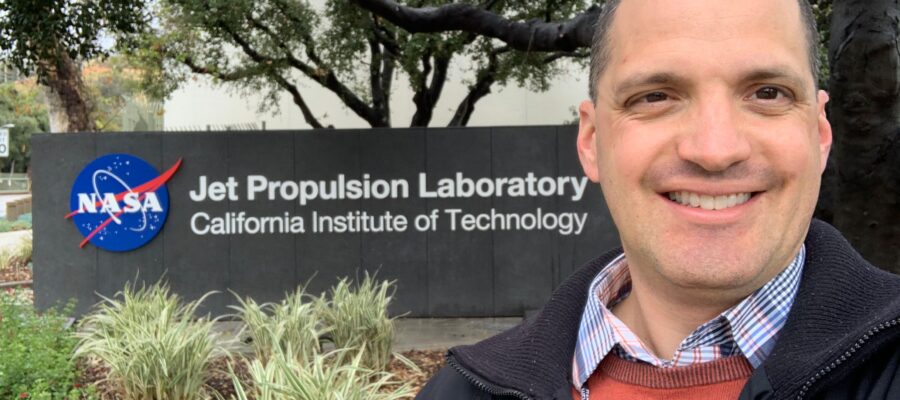 closeup smiling man before sign saying NASA Jet Propulsion Laboratory