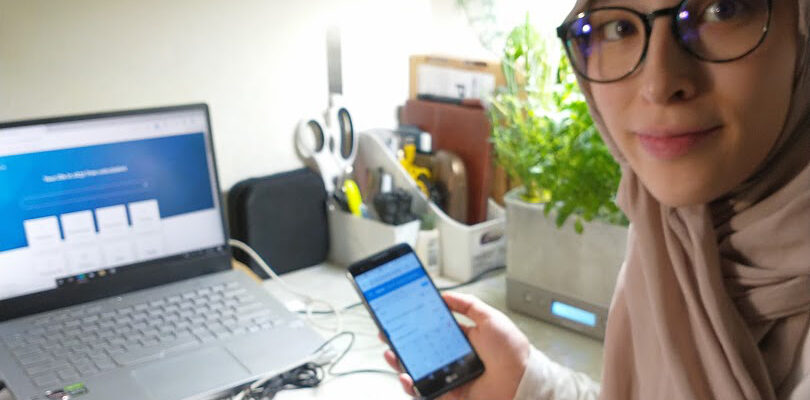 Head and shoulder of a woman holding cellphone in an office