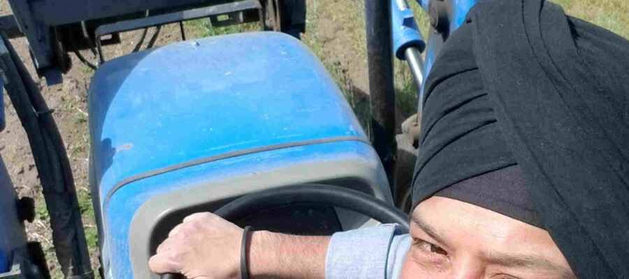 man looking back and smiling aboard tractor