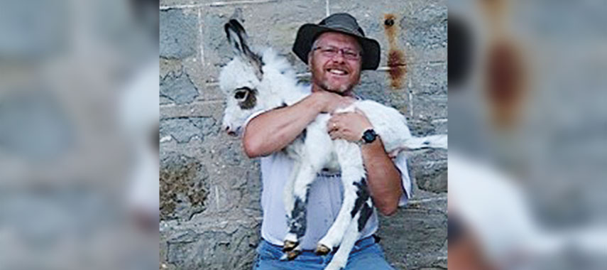 andy robinson holding a miniture donkey