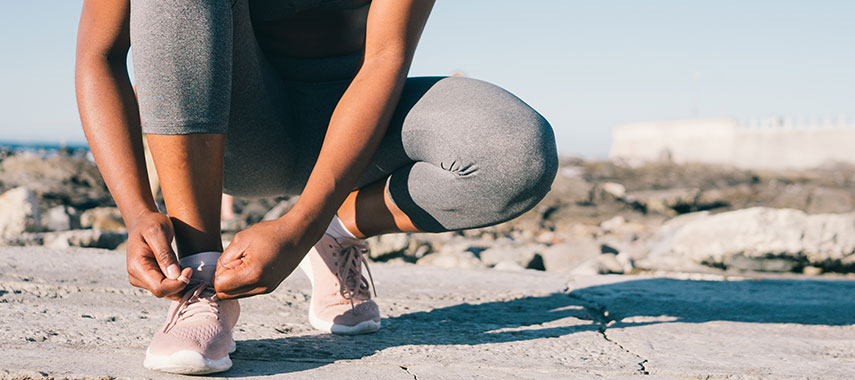 woman lacing up her running shoes