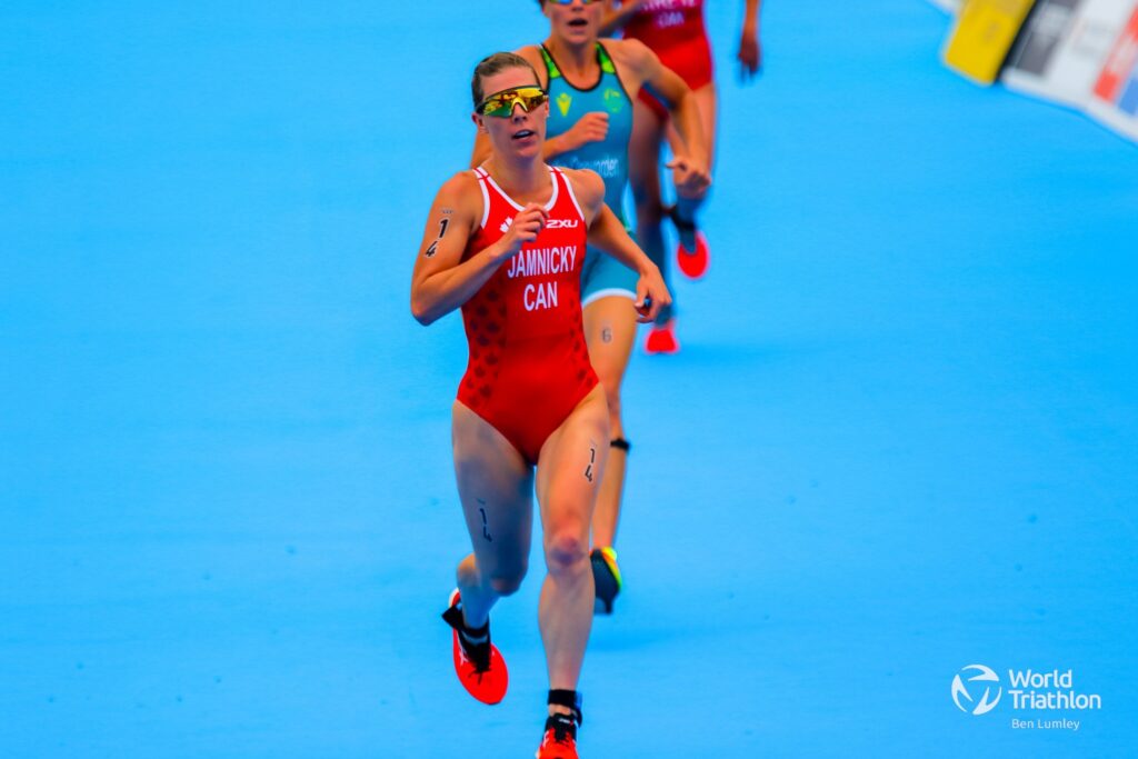 Dominika Jamnicky running in a red swimsuit on a blue track.