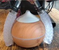 Close-up of the soft robotic gripper holding a small and curved humidifier