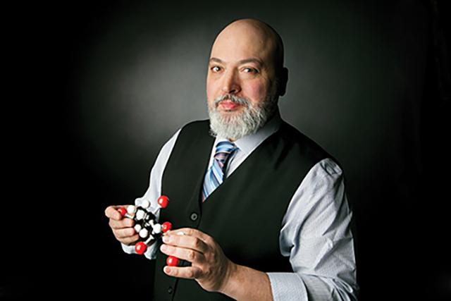 Photo of Prof. Mario Monteiro in a black vest and collared shirt with tie