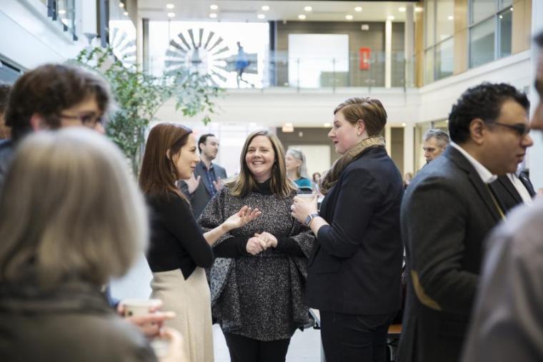 Professionals talking in networking-style setup in a brightly lit atrium