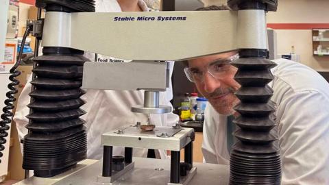 Dr. Alejandro Marangoni posing with his head in front of the mechanical mouth machine that assesses food texture