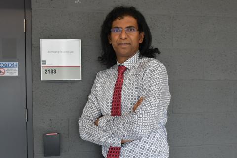 Dr. Manick Annamalai standing next to a sign for Bioimaging Research Solutions Inc.