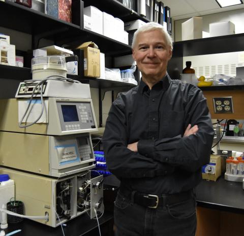 George Harauz stands beside equipment in his lab.