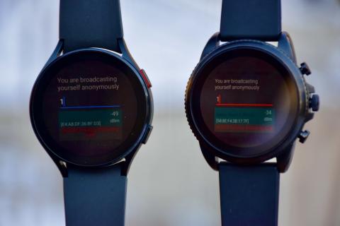 Two blue smartwatches for contact tracing that say, "You are broadcasting yourself anonymously."