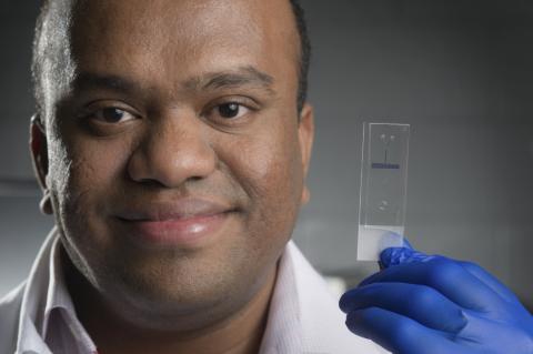 close-up of Suresh Neethirajan holding the lab on a chip