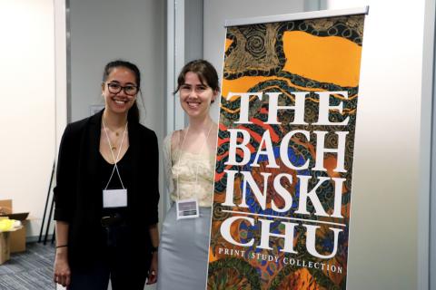 Two women standing next to a sign for the U of G’s Bachinski/Chu Print Study Collection 