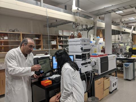A professor and a student together in a lab as he shows her samples