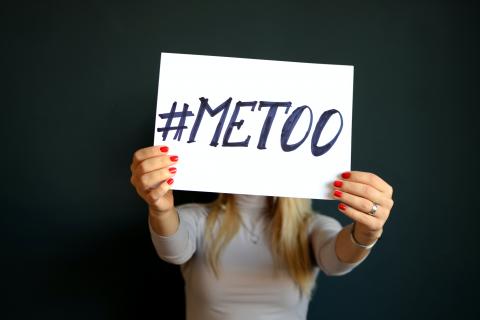 A woman holding a sign that says #MeToo