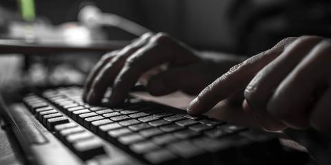 hands typing on a computer keyboard 