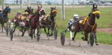 People racing horses on a track in carts