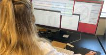 A woman with blond hair sitting in a front of a computer screen.