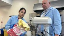 Food science master's student Vanessa Camacho-Martinez and food science professor Dr. Keith Warriner standing in front of a mixer with floor.