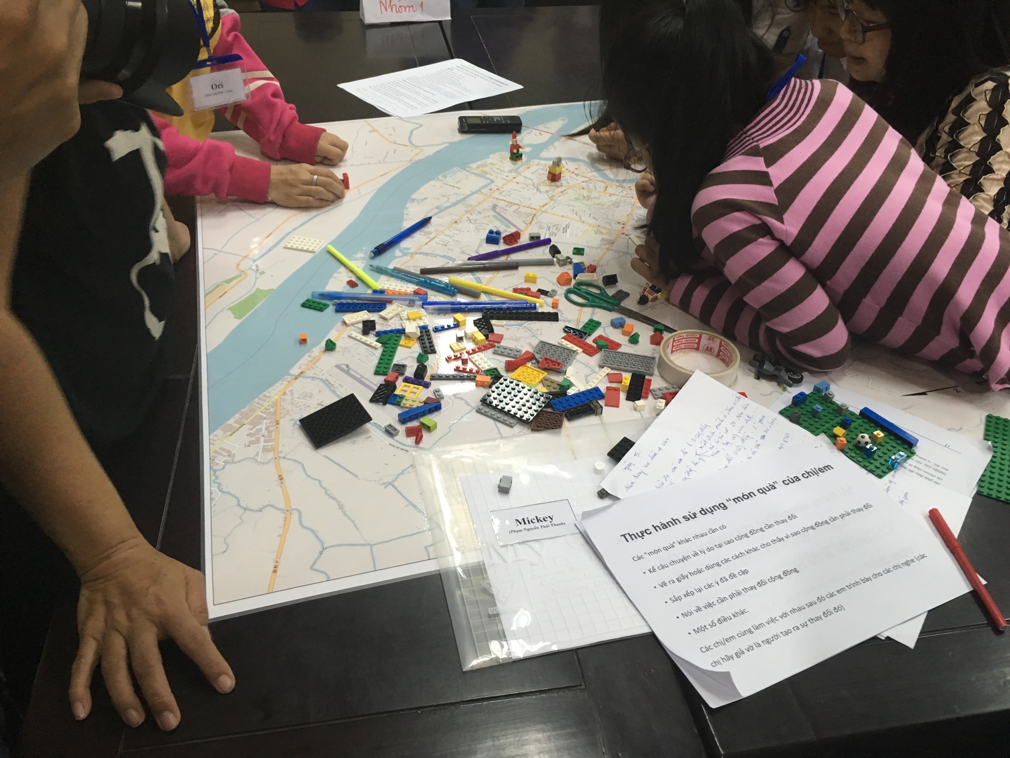 Girls surrounding a map with lego and documents