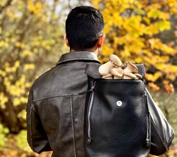 A man with a backpack with mushrooms in it