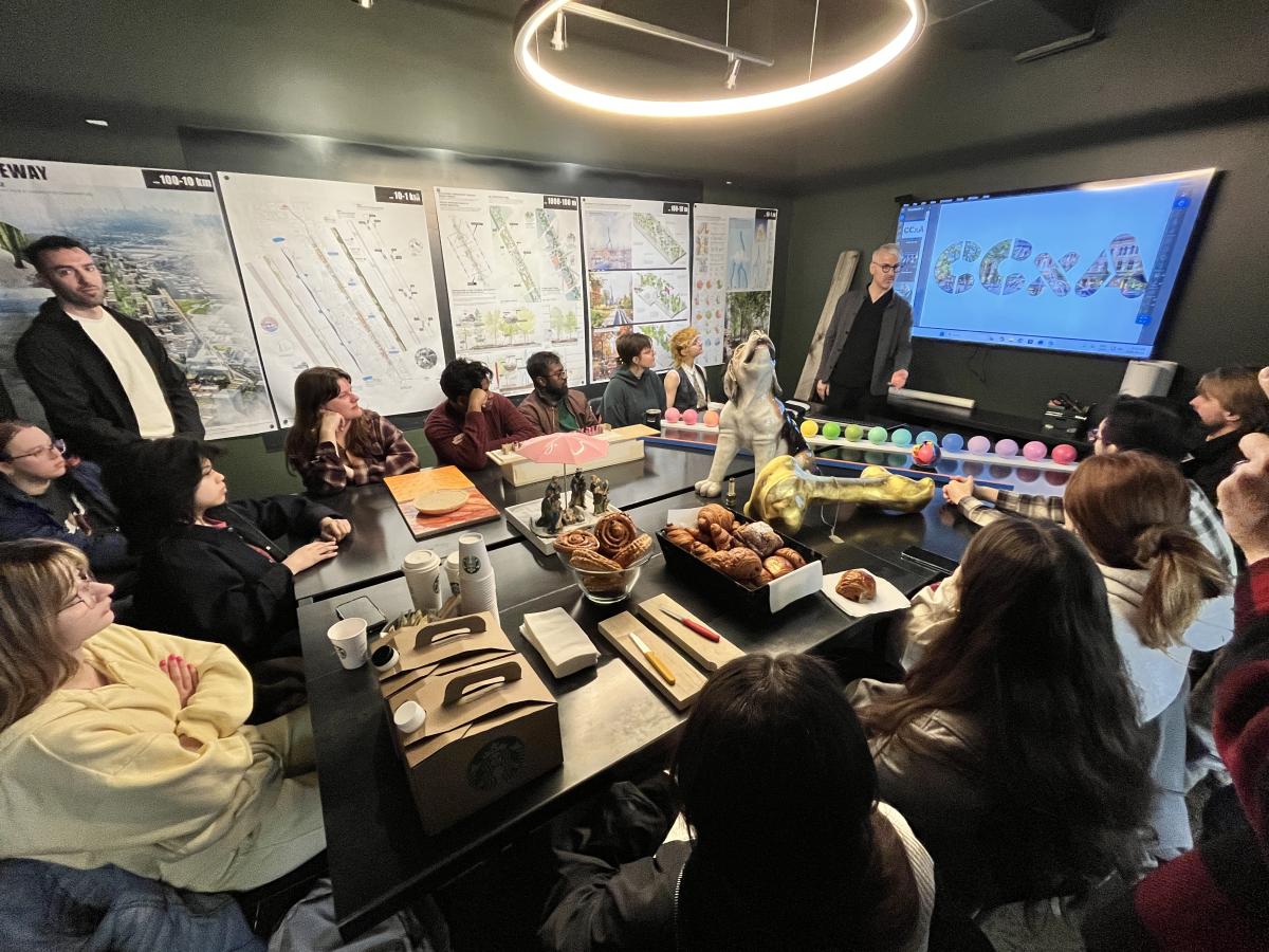 Students sitting listening to presentation at CCXA with mockups and maquettes on the table