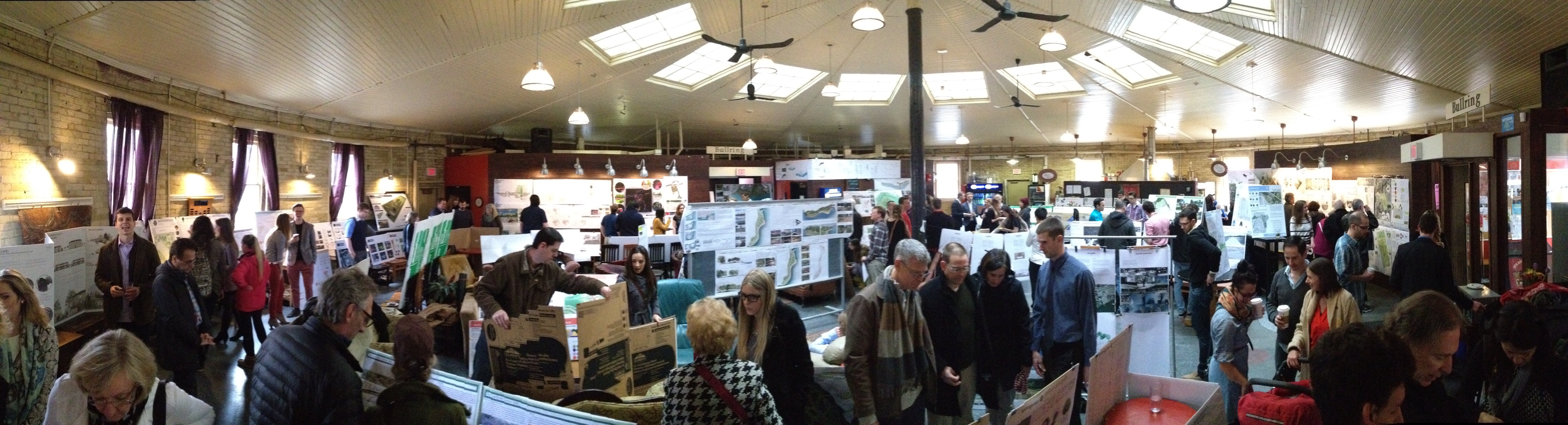Students and visitors viewing design panels inside the campus Bullring