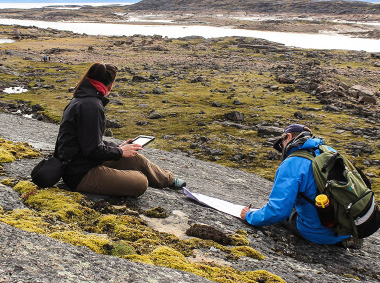 Two people conducting field work in the Arctic