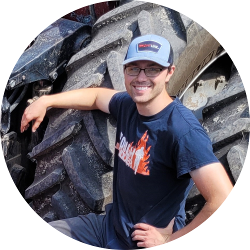 Dean Orr leaning on tractor wheel