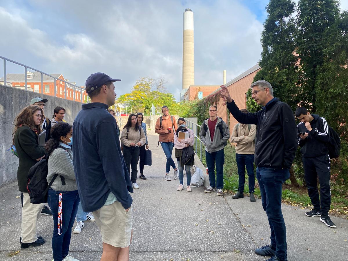 students in a circle outside listening to speaker