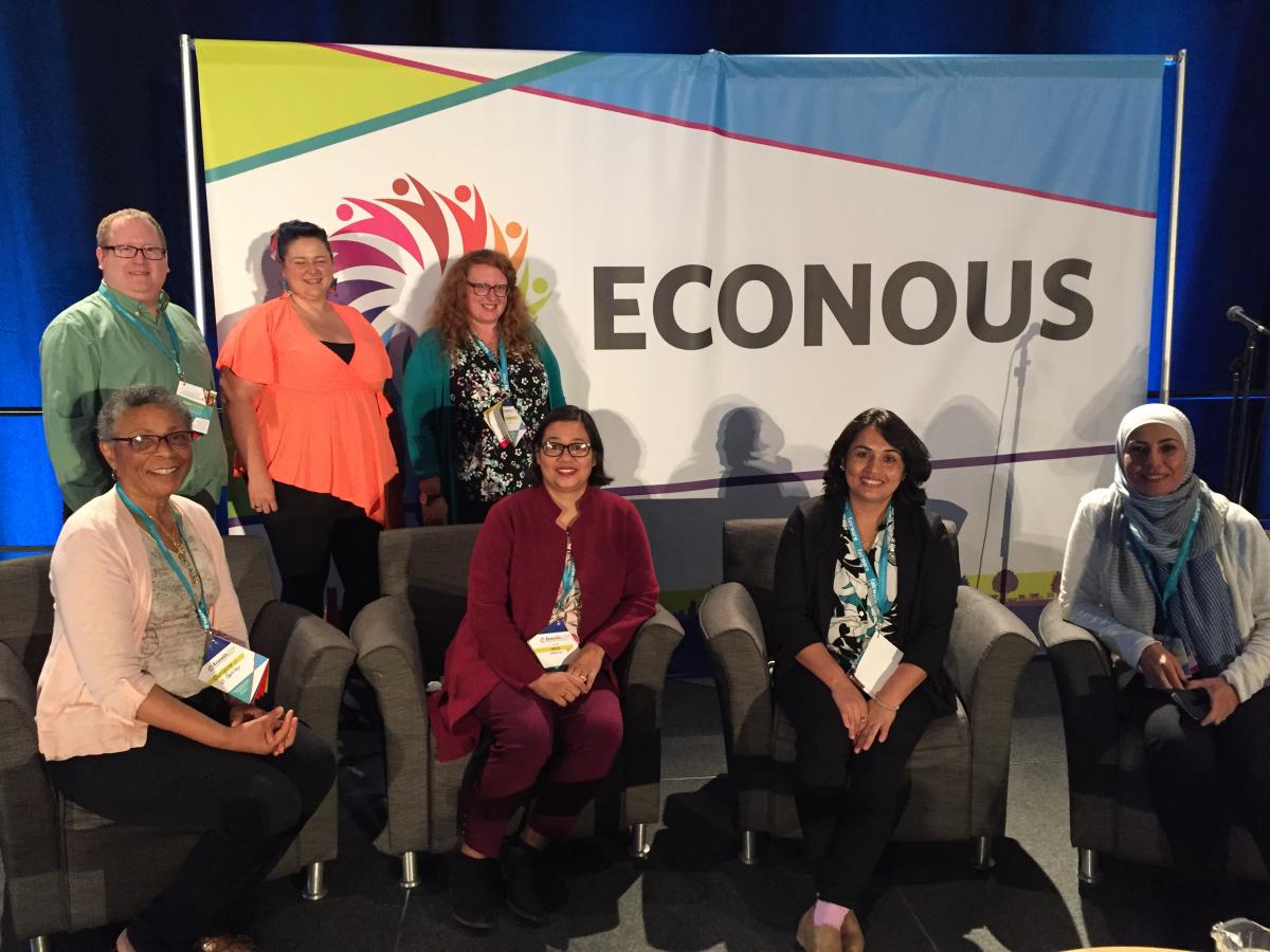 People in front of Econous Conference Banner