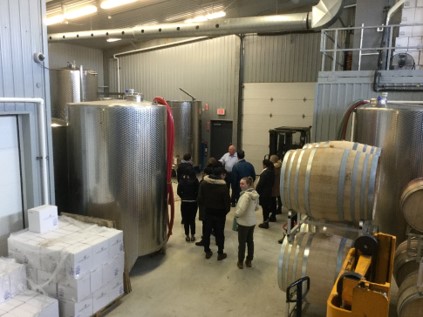 students standing inside wine production facility