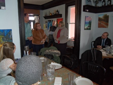 People gathered sitting and standing at cafe