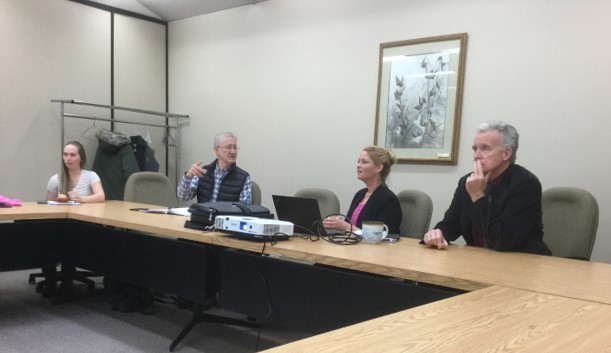 Four individuals sitting around boardroom table