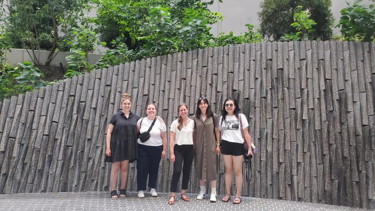 Students in front of wall and greenery