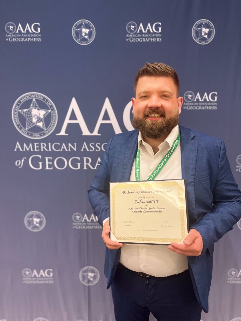 Josh Barrett holding certificate