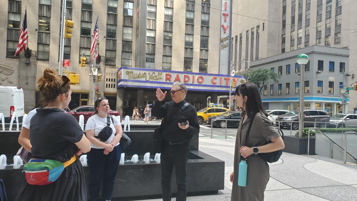 Students talking to Ken Smith on the street at Radio City Music Hall building in NYC.